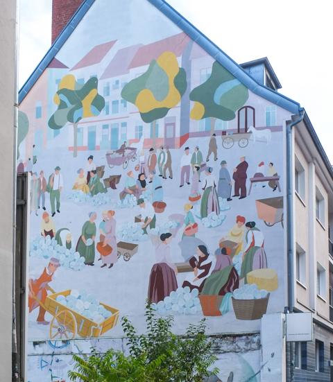 large mural in Nippes depicting daily life, making things, hauling, selling