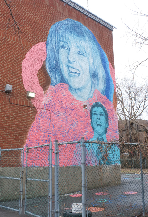 street art mural of actress Dominique Michel beside a small park in Montreal
