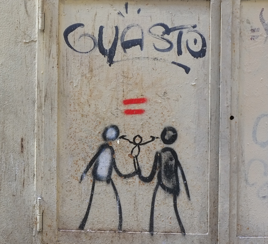 graffiti in Florence Italy by artist Exitenter, black drawing of two people, holding hands, with a small child added in the middle, red equal sign above child