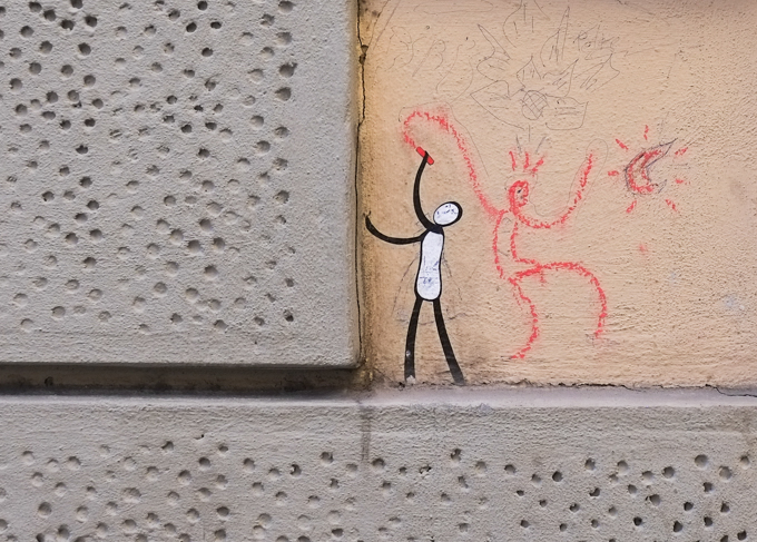 graffiti in Florence Italy by artist Exitenter, black drawing of a person looking up a wall, red crayon drawing of a second figure, holding hands with first and dancing