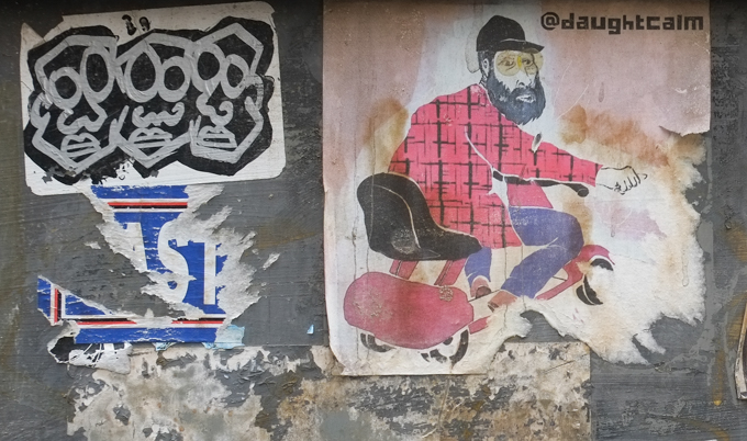two slaps on a door, one is by daught calm and is a man in a red plaid jacket with black hat and beard, riding on a motorized wheelchair, the other is three grey faces on black background