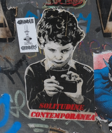 graffiti by Laben, child on smartphone with words solitudine contemporanea, also a small sticker for grundle grinders