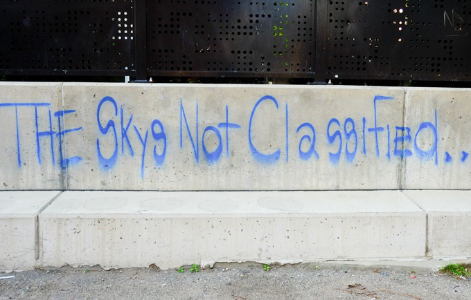 graffiti in blue that says the skys not classified