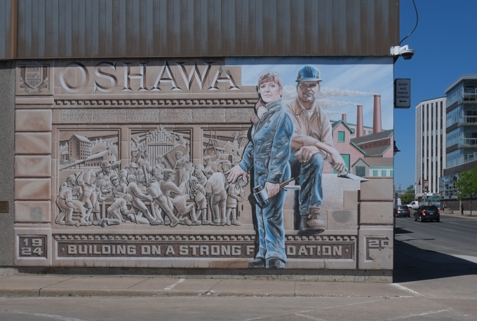 mural in oshawa with text Building on a strong foundation, by Robin Burgesse. Three local businesses are shown - Warren Mills, Williams Piano Factory, and the McLaughlin Carriage Company 