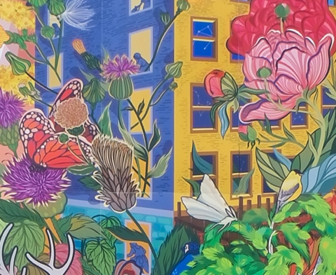 part of a seven storey tall mural on the side of a parking structure, by Dani Crosby, of old grist mill, with large water wheel, colourful, with flowers, fish in the creek, and other wildlife, butterflies, 