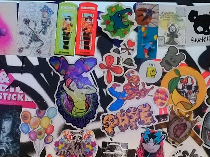 slaps on a wall in Windsor Melbourne, including D7606 telephone booth, tweet street art cat and balloons, a raccoon, spiderman, a skull, and others