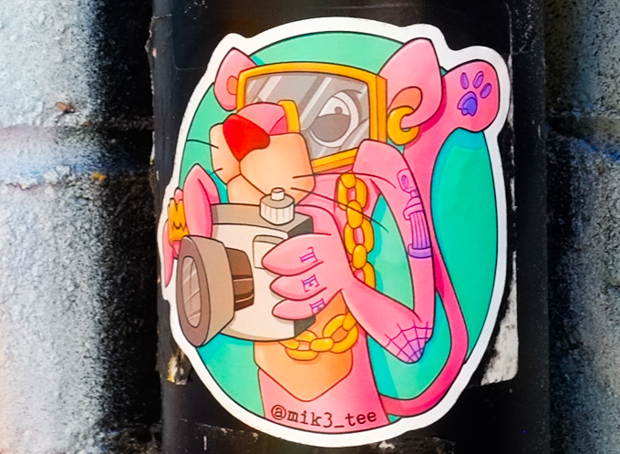round sticker graffiti,The Pink Panther sporting some tattoos and holding a camera, also wearing a swim mask, by mik3 tee