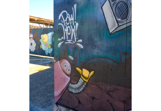 part of a larger mural by Eastthree in the foreground, with other mural in the background,