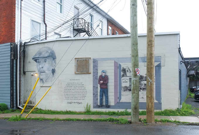 mural dedicated to Wayne Richards, milkman, also known as wandering Wayne, shown with an old horse drawn wagon milk cart from Maple Leaf dairy