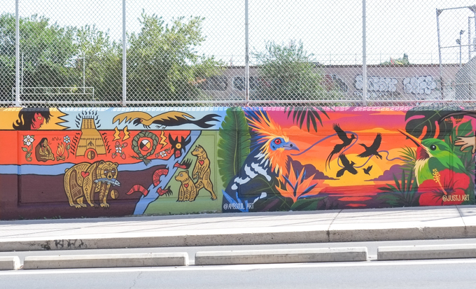 two street art murals on wall of railway underpass on Bloor street West. On the right side is collection of birds on the right side were painted by two artists Just J. and Ambsoul.  BJR painted the let side, first nations symbols and objects like a bear with a fish in its mouth, 