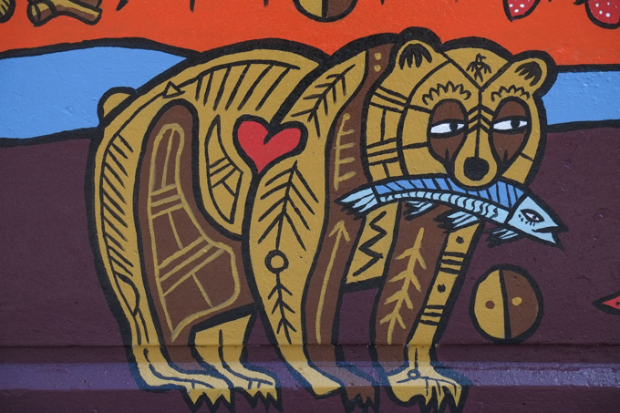 street art mural on wall of railway underpass on Bloor street West, byBJR, or Bradley J. Reinhart, bear with a blue fish in its mouth and a red heart on its side