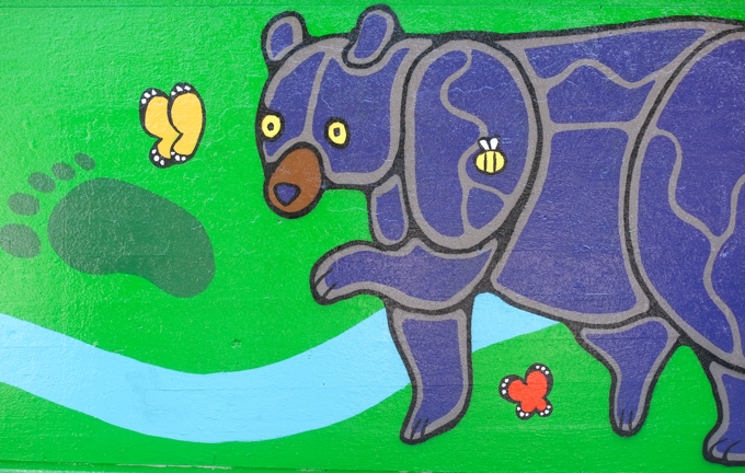 street art mural on wall of railway underpass on Bloor street West by Waskwane Designs, bear with a butterfly