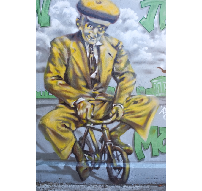 street art mural on wall of railway underpass on Bloor street West  painted by Adrian Hayles - an old man in yellow suit and hat, riding a very small yellow, or gold, bicycle