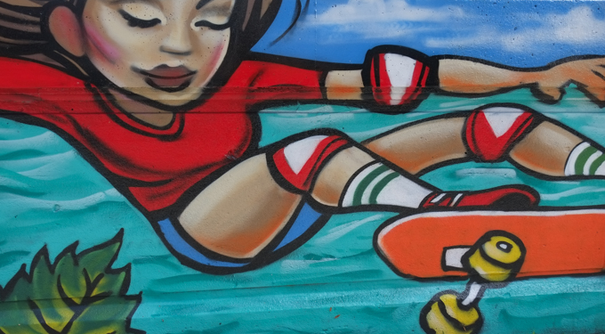 street art mural on wall of railway underpass on Bloor street West by EGR, a young woman skateboarding