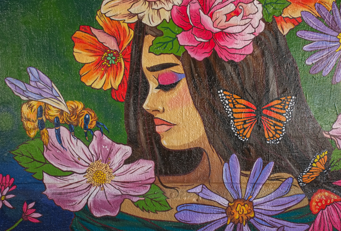 street art mural on wall of railway underpass on Bloor street West by Lula Lumaj, woman with long dark hair, flowers in her hair, monarch butterfly, bee, other flowers around her