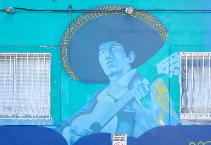 part of a mural, Dance the Dance My Girl by Ari de la Mora and Irving Cato in Vancouver, man wearing a sombrero and playing a guitar