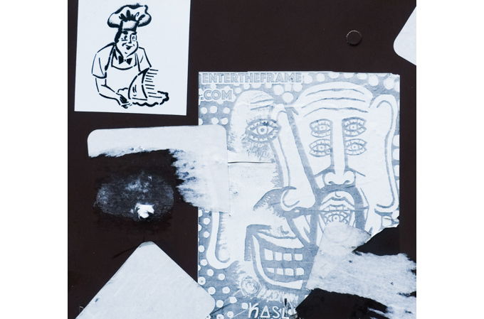 paste up graffiti, one is a chef with a shark's tail, the other is two male faces, both in black and white