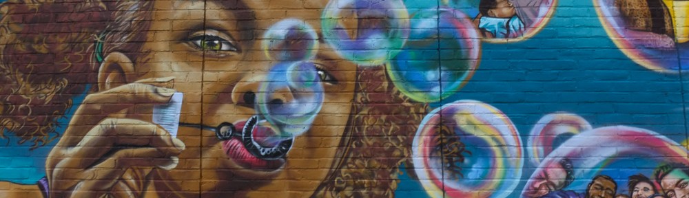 black or brown girl blowing bubbles, part of a mural in Nashua New Hampshire
