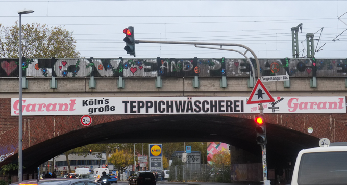 urban art, street art, in Cologne Germany, near Ehrenfeld station, train bridge over a street with traffic, the words love and peace painted on the bridge