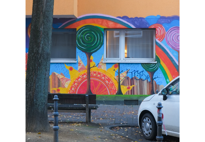 painting around window at front of building, rainbow and sun