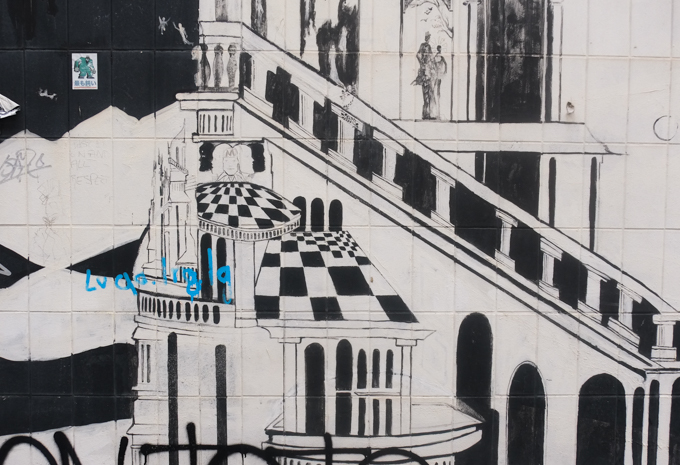 urban art, street art, in Cologne Germany, near Ehrenfeld station, part of mystical wall mural by Captain Borderline and Rakaposhii, building with balcony railing, black and white tiled roof