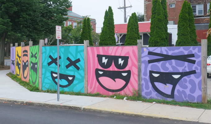 row of large happy faces on fence, different coloured backgrounds in each section, purple, pink, turquoise, green, orange, yellow, by Golden 305