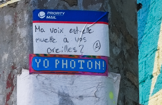 words in French written on a USA Priority mail sticker,  Ma voix est-elle muette a vos oreilles?