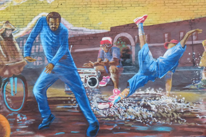part of Take Courage mural, young people dancing while some others watch