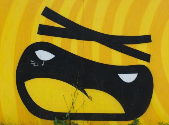 large x as eyes, face mural, black on yellow, by golden 305
