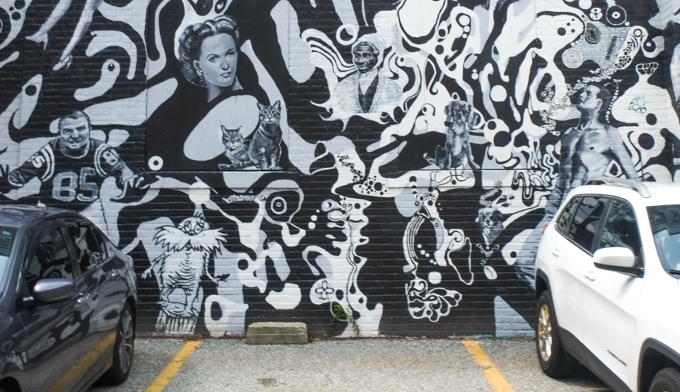 two cars parked in front of part of the Springfield mural, Dr. Suess character, cats, football player, dogs,