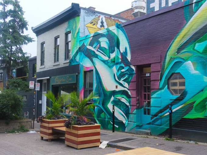 mural by Alex Bacon on Rue Duluth in Montreal, large face that looks like its sleeping, also painted to look metallic, chrome like