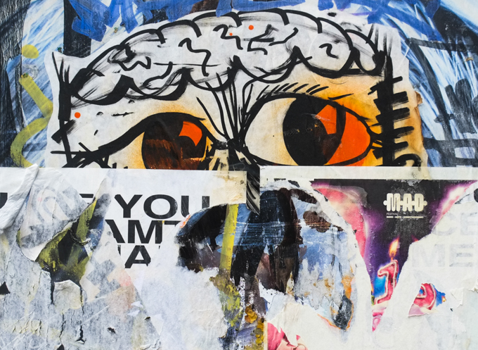 eyes, from an older piece of street art where the lower parts of the face have been papered over with other graffiti, now torn