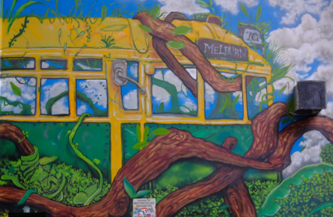 Part of a mural in Gallaghers Place in Melbourne, by Mike Makatron and Conrad Bizjak, overgrown abandoned city. A Melbourne tram with some very strong looking vines growing over it as well as in and out of the windows.