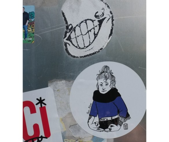 stickers on the back of a sign