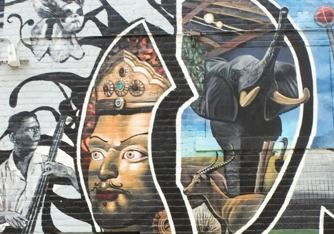 part of the Springfield mural, elephant, man playing bass, gold face with gold and bejeweled crown,