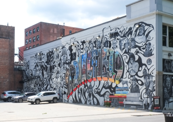 mural in Springfield Massachusetts, with word Springfield in capital letters and in colour, with illustrations inside the letters and black and white images of people and things associated with the city