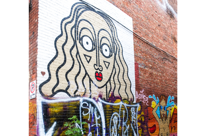 part of mural by Sara Erenthal, woman with surprised expression on her face, black line drawing but with red mouth